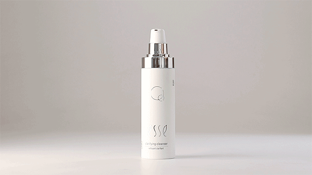 A white bottle of Esse Clarifying Cleanser with a silver pump top is displayed against a plain background. The bottle's label showcases minimalistic branding with subtle design elements.