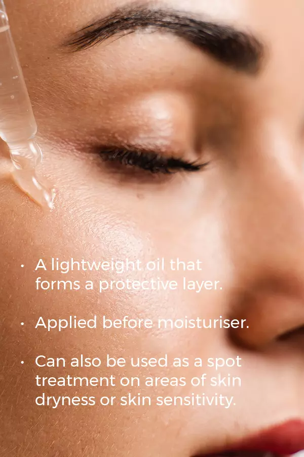 A close-up shows a woman’s face with closed eyes as Esse Protect Oil is applied to her cheek. It's a lightweight oil used after moisturizer for dry or sensitive skin, and can also be applied as a targeted spot treatment.