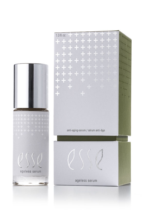 A bottle of Esse Ageless Serum with a silver cap is showcased beside its matching silver and green box, both featuring minimalist labeling and plus sign designs.